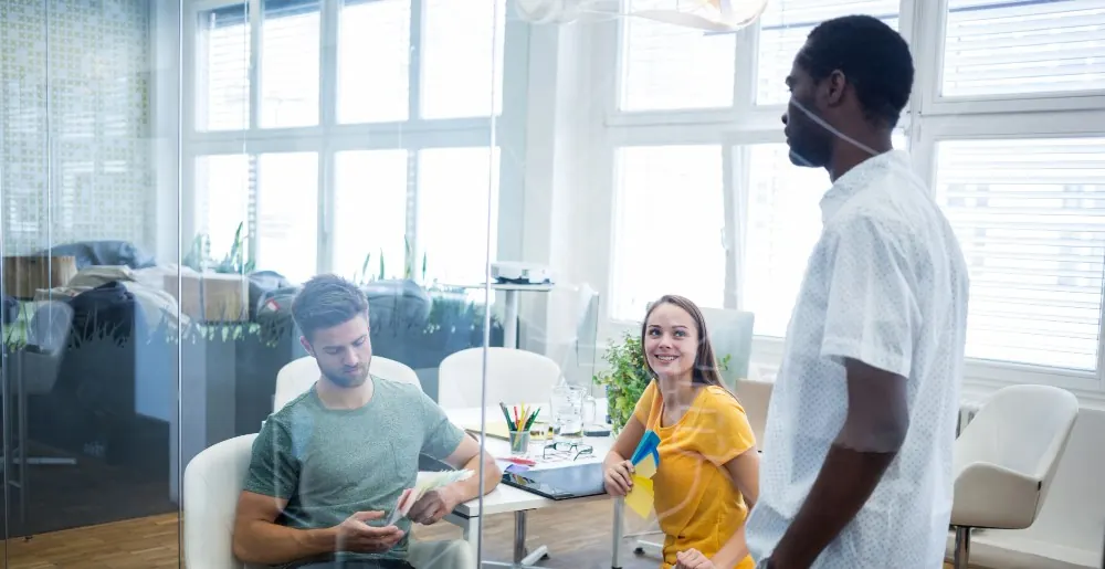Team members collaborating in a modern office space with natural lighting